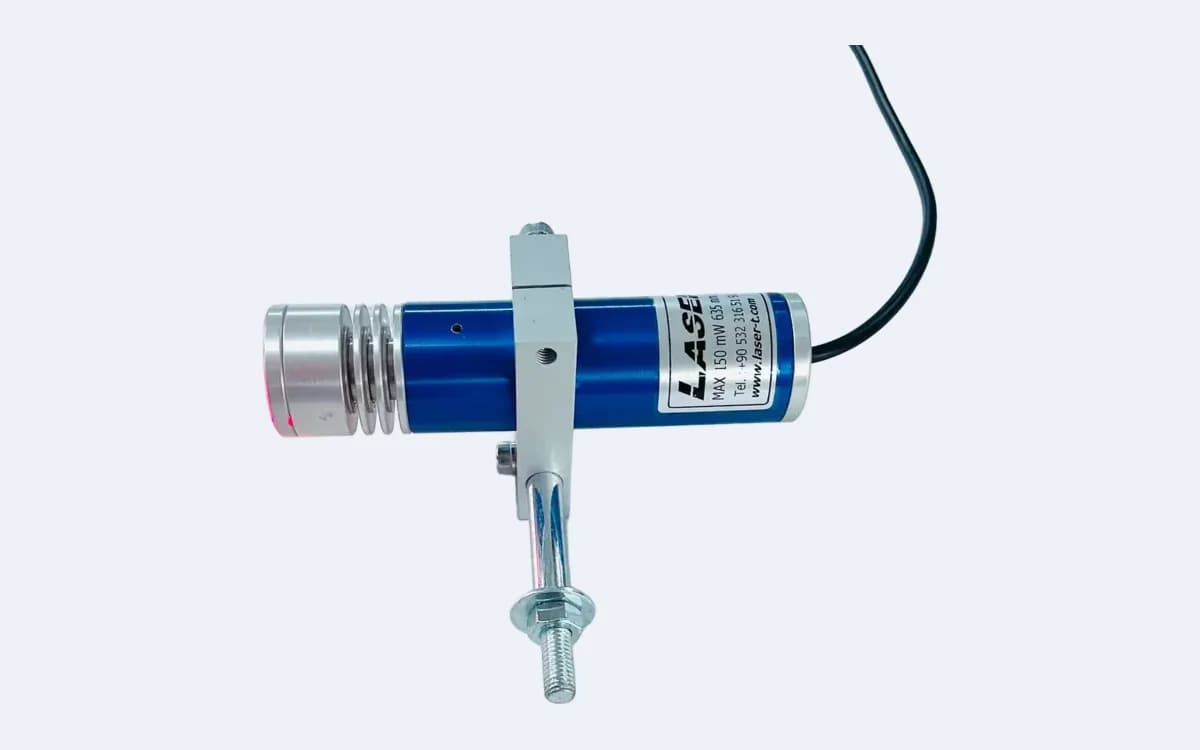 TM200L35 çizgi lazer yatay duruşta — kanatlı lens başlığı solda, kablo sağda, montaj mili tutucudan aşağı iniyor