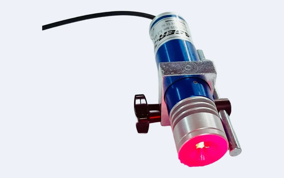 TM200L35 çizgi lazer lens önden, kırmızı yanarken — sıkma topuzu solda, montaj mili sağda, kablo sol üstte