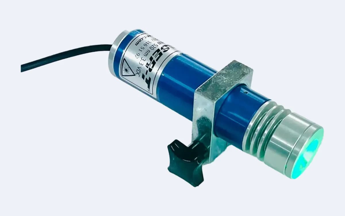 TOD100C35 yeşil daire lazer çapraz açıdan — lens sağda yeşil yanıyor, sıkma topuzu tutucunun altında, kablo solda