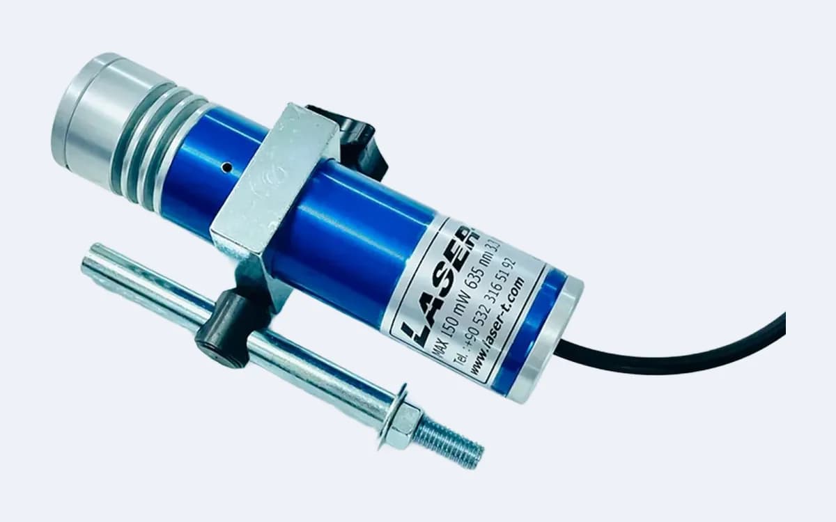 TOD150C35 daire lazer çapraz açıdan — lens başlığı sol üstte, montaj mili gövdenin altında, kablo sağda