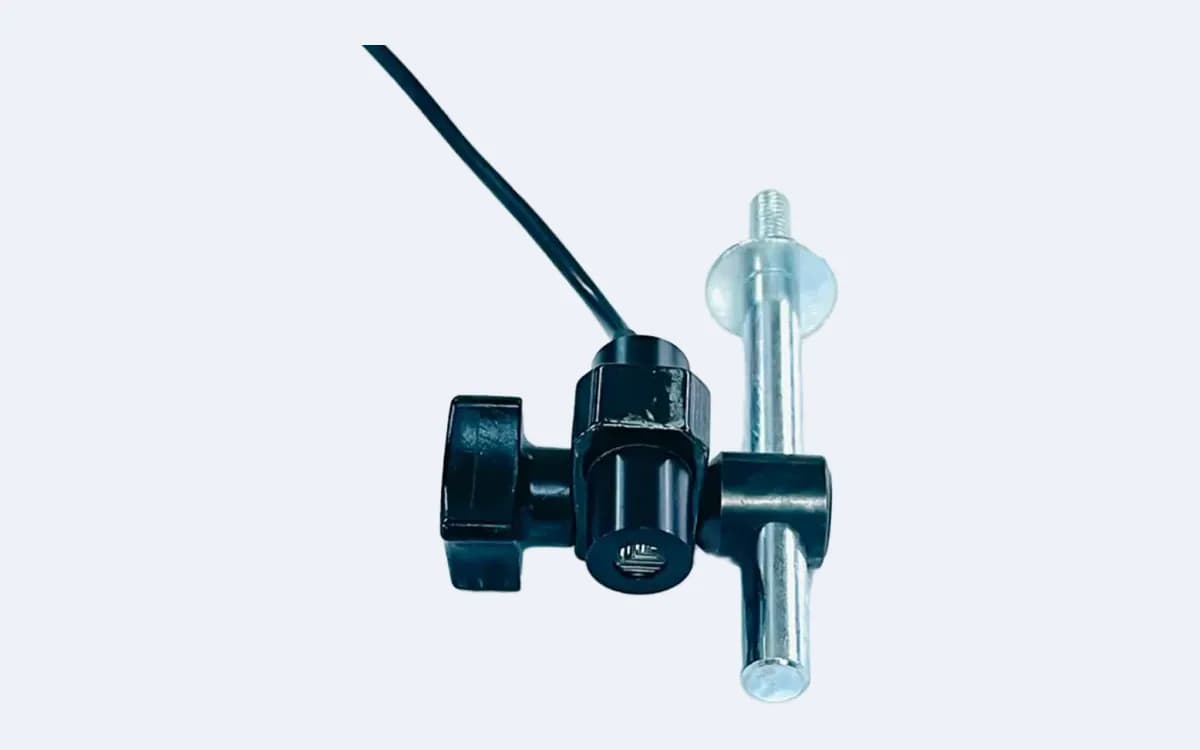 MAX5N12 nokta lazer lens penceresi önden — sıkma topuzu solda, montaj mili sağda, kablo sol üstten geliyor