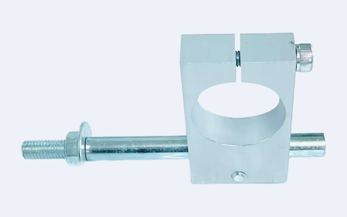 LASER-T TB 25 bağlantı aparatı — gümüş alüminyum kelepçe bloğu ortada, 25 mm gövdeyi kavrayan yuvasıyla; çinko kaplı çelik mil altta yatay geçiyor, sol ucunda pullu dişli saplama, sağ üstte tırtıllı sıkma vidası
