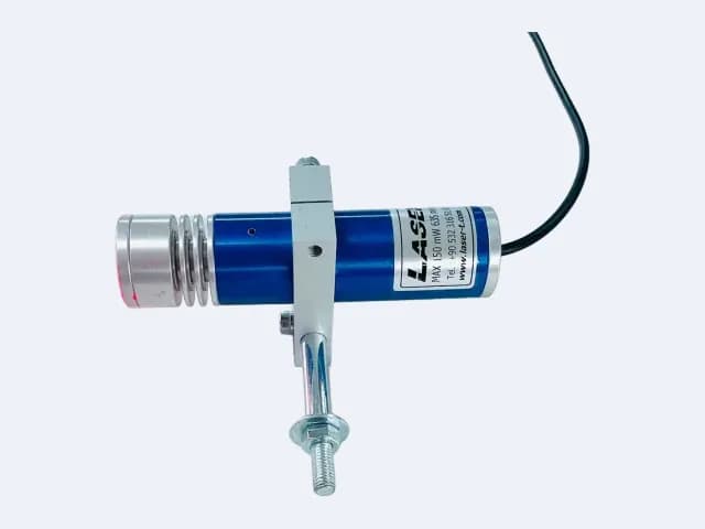 TM100L35 çizgi lazer yatay duruşta — kanatlı lens başlığı solda, kablo sağda, montaj mili tutucudan aşağı iniyor