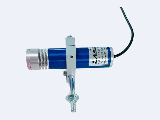 TM200L35 çizgi lazer yatay duruşta — kanatlı lens başlığı solda, kablo sağda, montaj mili tutucudan aşağı iniyor